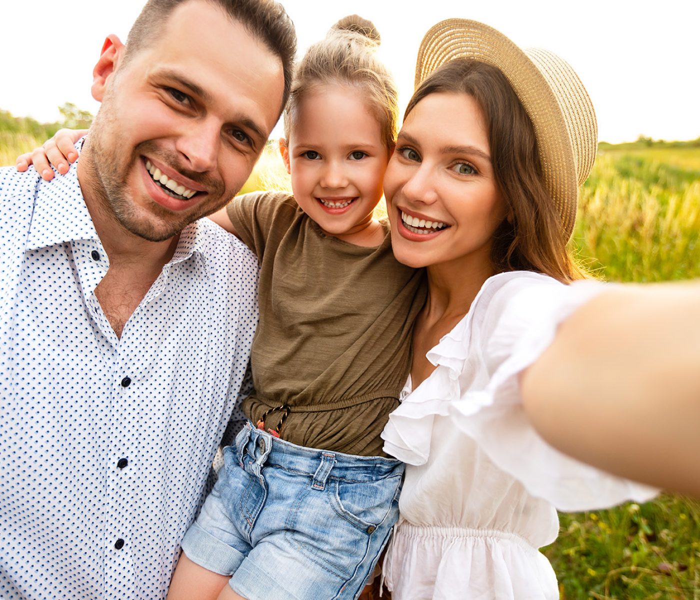 Family Portrait. Closeup of adorable couple with cute kid taking selfie, having fun outdoors