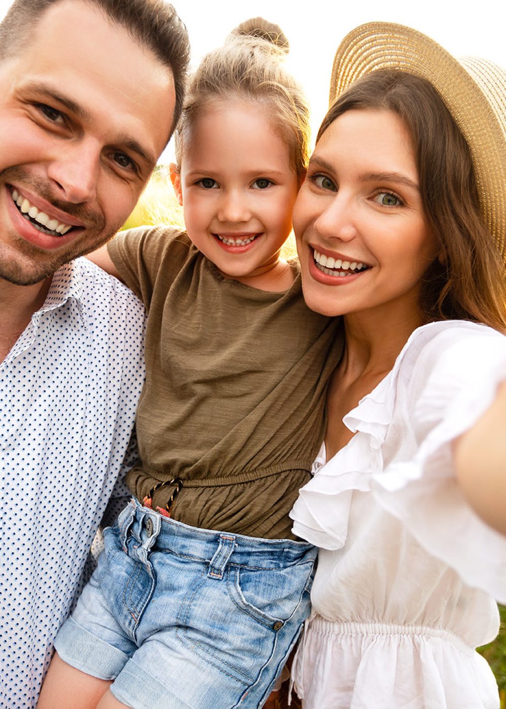 Family Portrait. Closeup of adorable couple with cute kid taking selfie, having fun outdoors